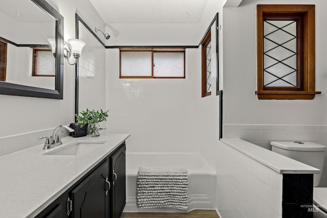 full bathroom featuring toilet, vanity, and tiled shower / bath