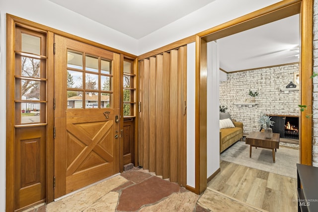 entryway featuring a brick fireplace and light hardwood / wood-style floors