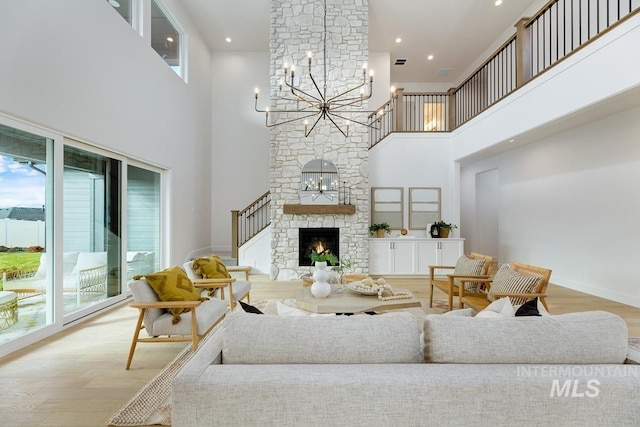 living room with plenty of natural light, wood-type flooring, a towering ceiling, and a fireplace