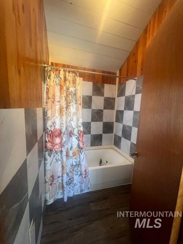 2070 Woodland Rd, Kamiah, ID 83536 - bathroom with vaulted ceiling, wooden walls, tile walls, wood finished floors, and shower / tub combo
