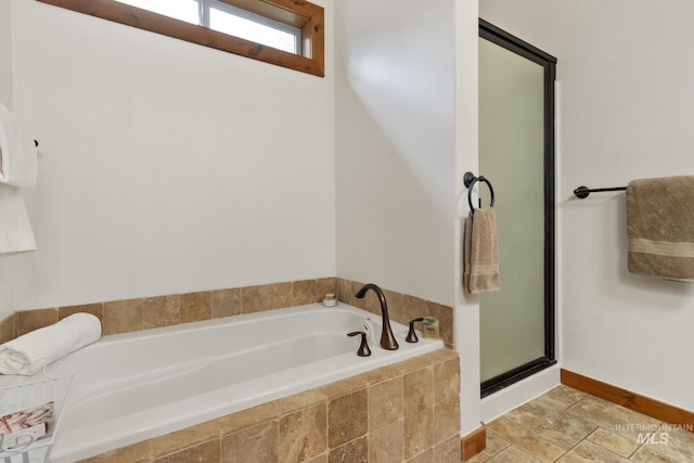 full bathroom featuring a stall shower, a bath, and tile patterned floors