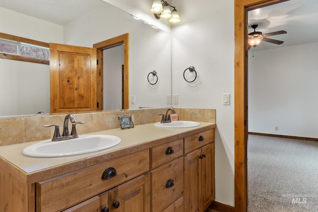 full bathroom featuring a sink, baseboards, and double vanity