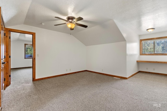 bonus room with a textured ceiling, baseboards, and carpet flooring