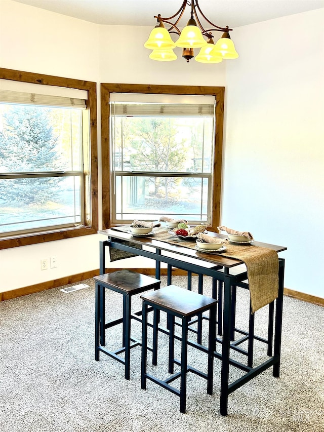 carpeted dining space featuring a chandelier, visible vents, and baseboards