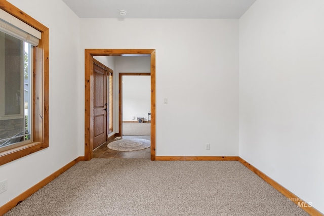 empty room featuring carpet floors and baseboards