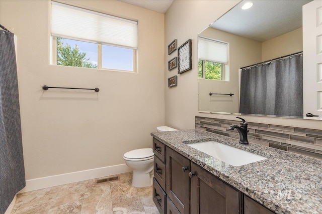 bathroom with vanity, backsplash, and toilet