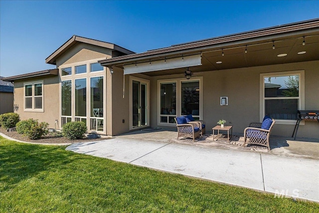 back of property with a yard, a patio area, and ceiling fan