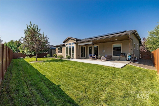 back of property featuring a patio area, solar panels, and a lawn