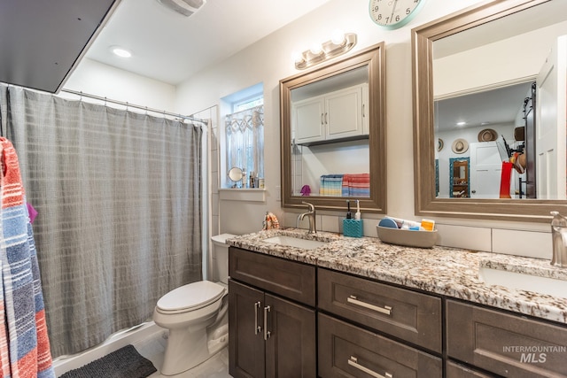 bathroom featuring walk in shower, vanity, and toilet