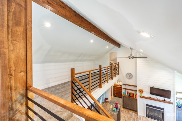 interior space featuring vaulted ceiling with beams, a fireplace, and hardwood / wood-style flooring