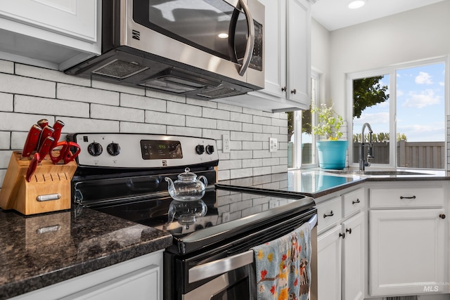 2145 W Quilceda, Kuna, ID 83634 - kitchen with stainless steel appliances, decorative backsplash, white cabinets, a sink, and dark stone countertops