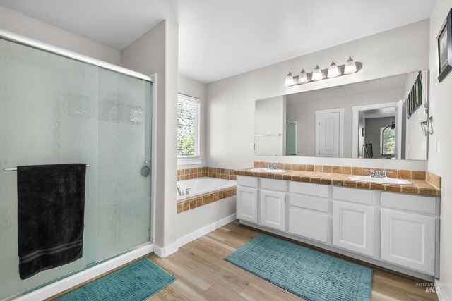2145 W Quilceda, Kuna, ID 83634 - full bathroom featuring a bath, a stall shower, double vanity, and wood finished floors