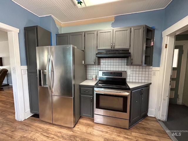 kitchen featuring tasteful backsplash, ornamental molding, stainless steel appliances, light hardwood / wood-style flooring, and gray cabinets