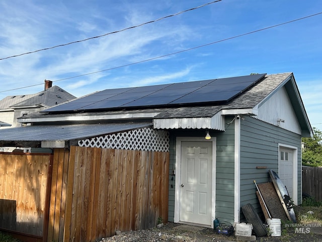 rear view of house featuring solar panels