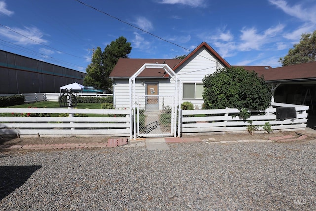 bungalow-style home with a fenced front yard and a gate