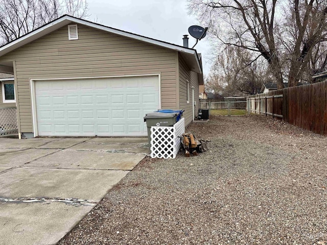 view of side of property featuring central air condition unit and a garage