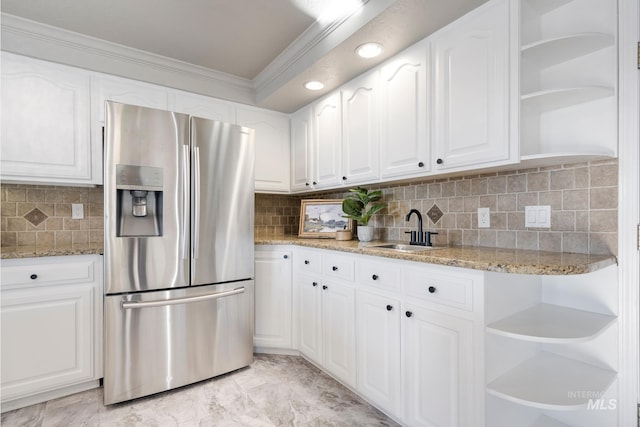 kitchen featuring white cabinets, decorative backsplash, stainless steel refrigerator with ice dispenser, and sink