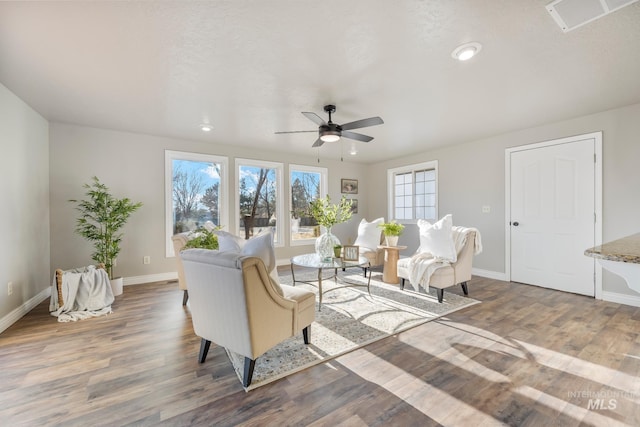 living room with wood-type flooring, a textured ceiling, and ceiling fan