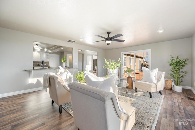 living room with sink, ceiling fan, and dark hardwood / wood-style floors