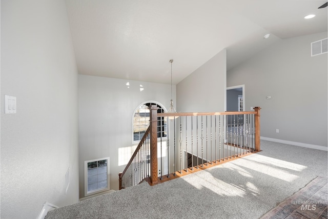 staircase with carpet, an inviting chandelier, and vaulted ceiling