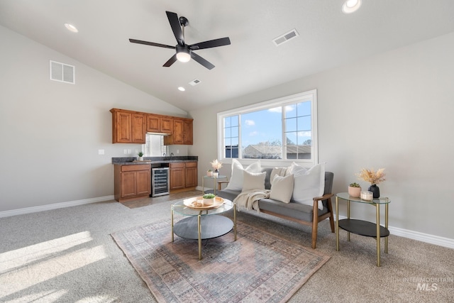 carpeted living room featuring beverage cooler, ceiling fan, and vaulted ceiling