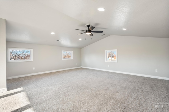 empty room featuring vaulted ceiling, ceiling fan, and carpet