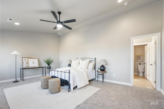 bedroom featuring lofted ceiling, ensuite bath, light carpet, and ceiling fan