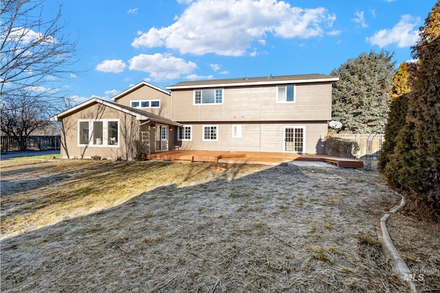 rear view of property featuring a lawn and a wooden deck