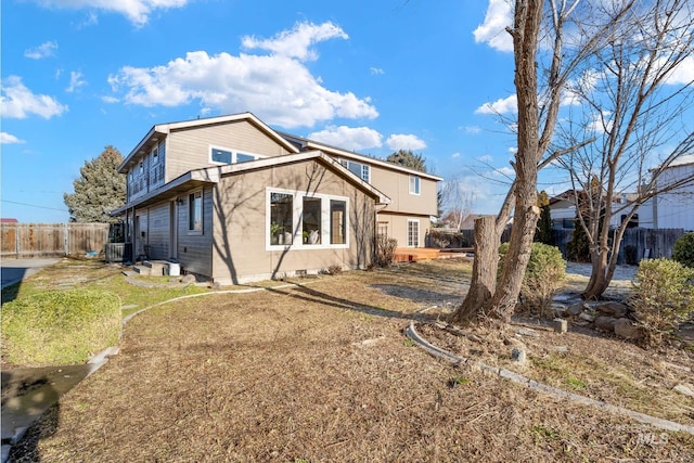 rear view of property with a lawn and central AC unit