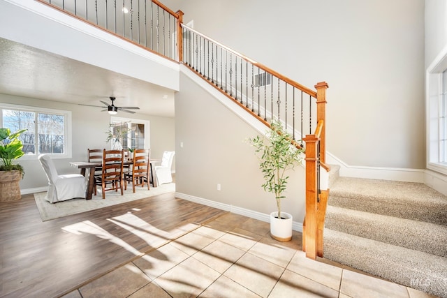 stairway with ceiling fan and tile patterned flooring