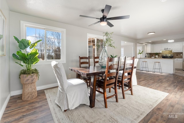 dining area featuring sink, ceiling fan, and dark hardwood / wood-style floors