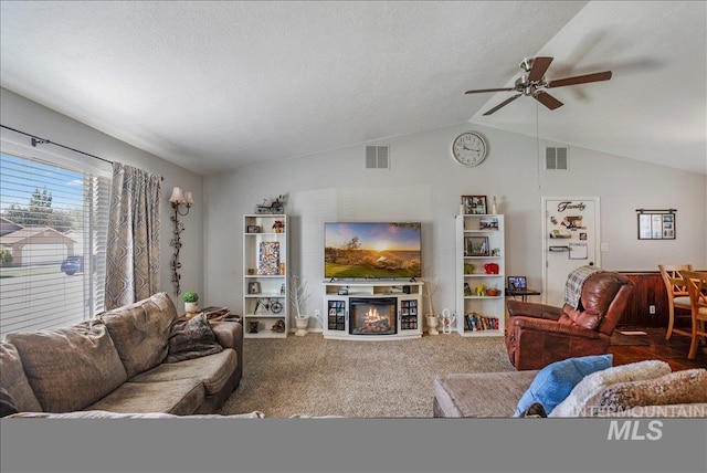 206 Diamond Dr, Kimberly, ID 83341 - living area with ceiling fan, carpet floors, vaulted ceiling, a glass covered fireplace, and a textured ceiling