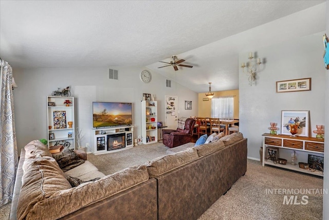 206 Diamond Dr, Kimberly, ID 83341 - carpeted living area featuring a ceiling fan, lofted ceiling, and a glass covered fireplace