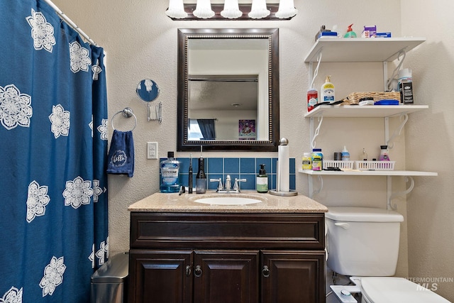 bathroom featuring tasteful backsplash, vanity, and toilet