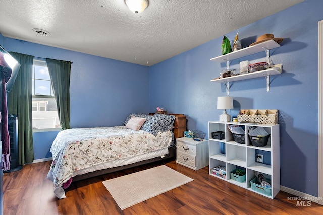 bedroom featuring dark wood-type flooring and a textured ceiling