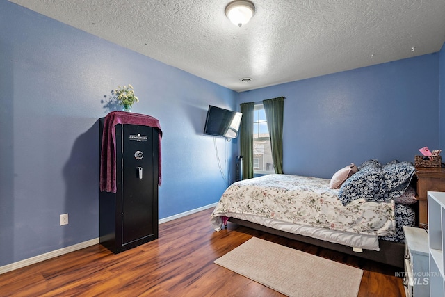 bedroom featuring dark wood-type flooring and a textured ceiling