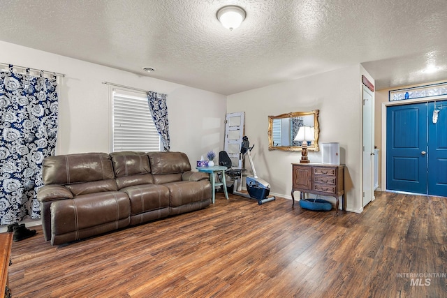 living room with dark wood-type flooring and a textured ceiling