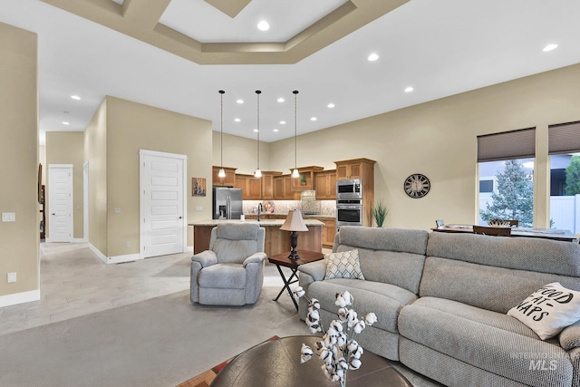 living area featuring recessed lighting, baseboards, and a towering ceiling
