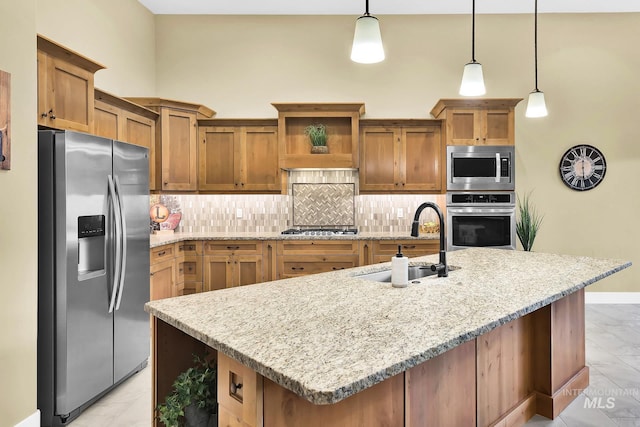 kitchen with appliances with stainless steel finishes, a sink, backsplash, decorative light fixtures, and baseboards