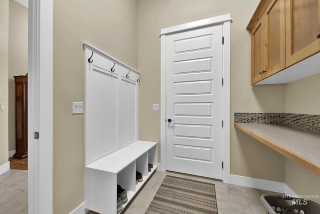 mudroom with baseboards and light marble finish floors
