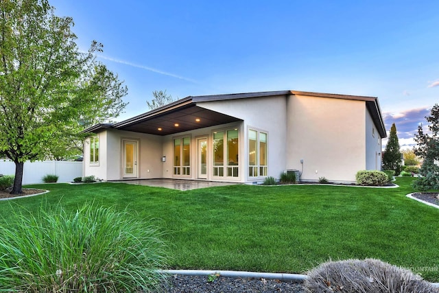 rear view of house featuring stucco siding, a patio, and central AC