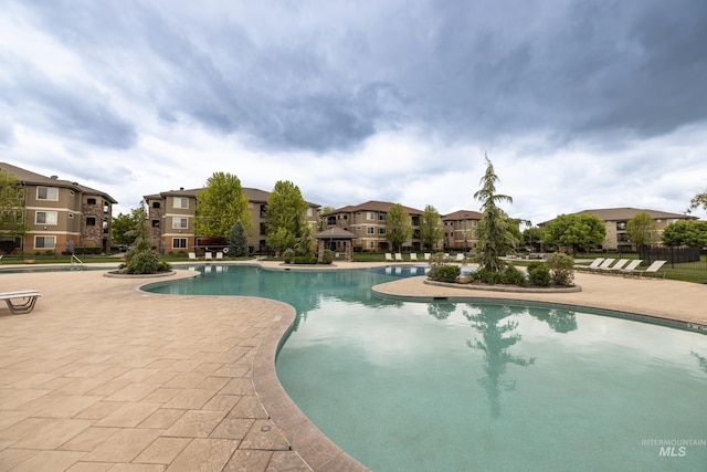 community pool with a patio and a residential view