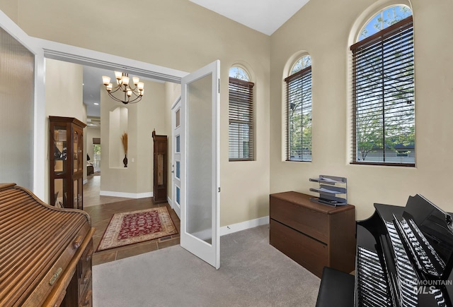 foyer entrance with a chandelier and baseboards