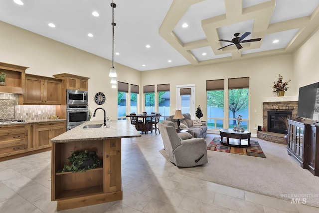 living area featuring a towering ceiling, a ceiling fan, recessed lighting, a fireplace, and coffered ceiling