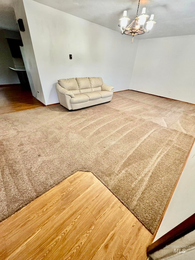 living room with lofted ceiling, a notable chandelier, and carpet flooring