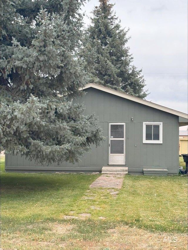 rear view of property featuring a lawn