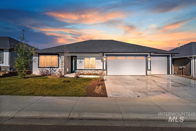 single story home featuring a shingled roof, an attached garage, a front yard, stone siding, and driveway