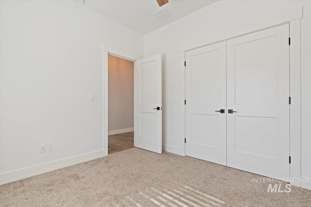 unfurnished bedroom featuring a closet, carpet, and baseboards