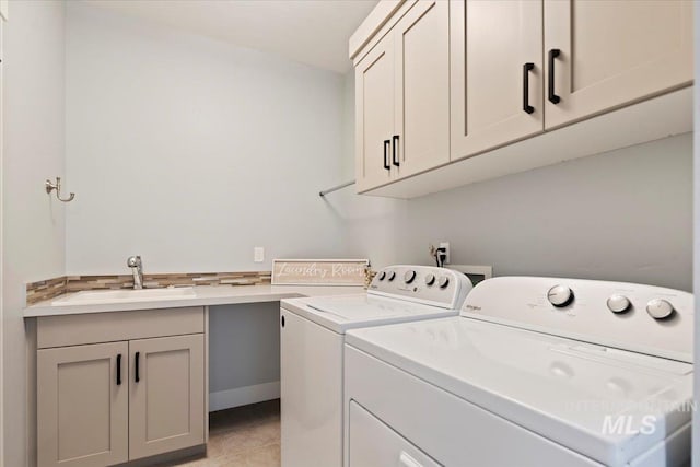 clothes washing area featuring cabinet space, a sink, washing machine and clothes dryer, and light tile patterned flooring