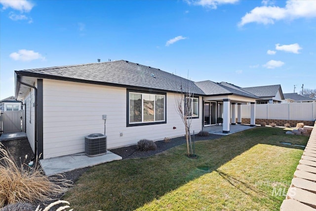 back of house featuring roof with shingles, a yard, a patio, fence, and cooling unit